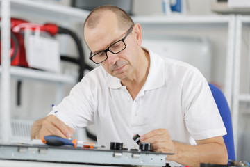technician fixing motherboard by soldering chips