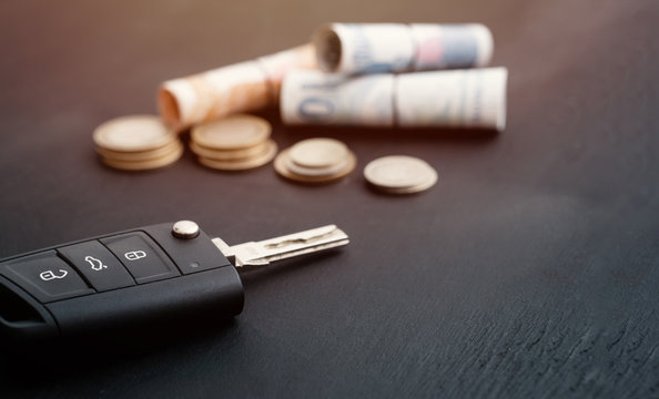 car key and coins on black background, concept photo for car finance industry
