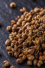 Sichuan pepper on a dark stone background