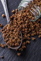 Sichuan pepper on a dark stone background