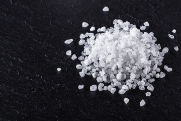 coarse sea salt on a dark stone background