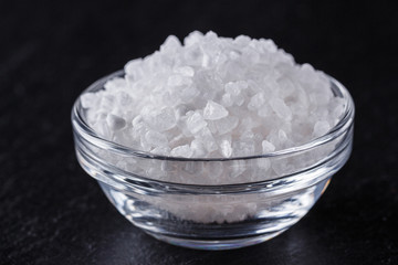 coarse sea salt on a dark stone background
