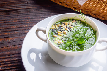 broccoli spinach cream soup on rustic wooden background