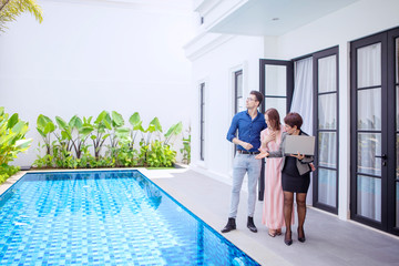 Woman showing pool of the new home to the couple