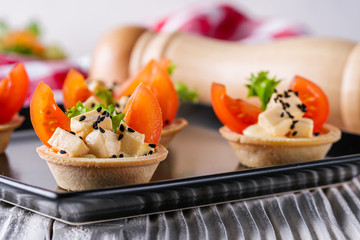 delicious snack tartlets on rustic wooden background