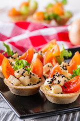 delicious snack tartlets on rustic wooden background