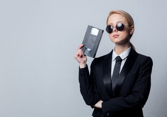 businesswoman in sunglasses with video tape - obrazy, fototapety, plakaty