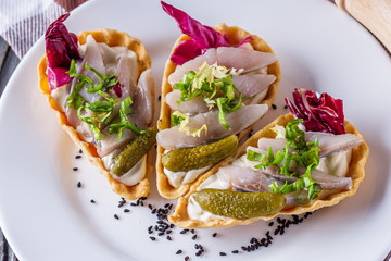 delicious snack tartlets on rustic wooden background