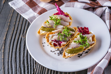 delicious snack tartlets on rustic wooden background
