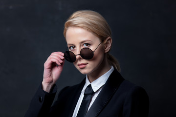 Style businesswoman in a classic black business suit and sunglasses