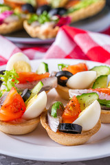 delicious snack tartlets on dark stone background