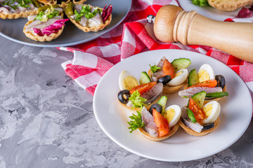 delicious snack tartlets on dark stone background