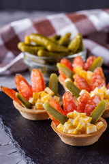 delicious snack tartlets on dark stone background