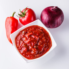 Fresh tasty tomato sauce on a white background