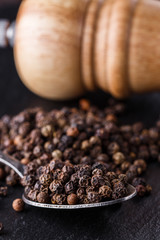 aromatic black pepper on a dark stone background