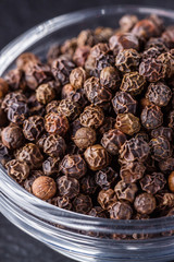 aromatic black pepper on a dark stone background