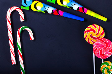 Top view of various bright colored lollipops on a black background. Children party concept.