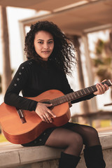 Brunette girl playing classical guitar
