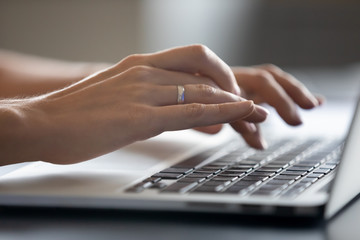 Close up young woman typing message in social networks on computer, web surfing information,...