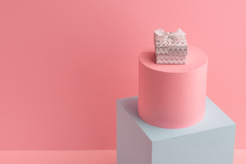 Little sparkling silver gift box on pink background with copy space