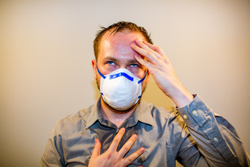 Man with real Coronavirus COVID-19 disease symptoms wears a protective mask