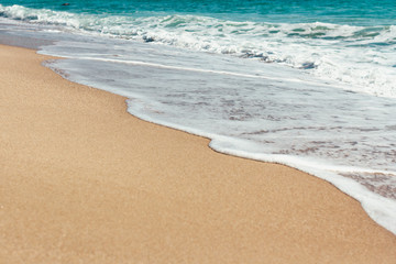 Fototapeta na wymiar Deserted beach Sea waves overlook the sandy shore Summer background