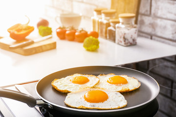 Frying pan with cooked eggs on stove