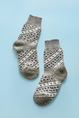 Knitted socks on color background