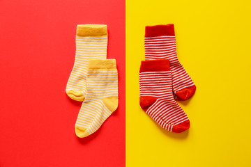 Different cotton socks on color background