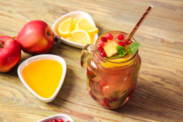 Mason jar of cold tea and ingredients on wooden table