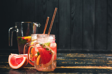 Mason jars of cold tea on dark wooden table