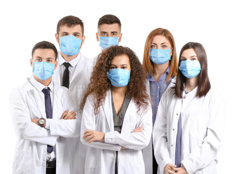 Group Of Doctors With Protective Masks On White Background. Concept Of Epidemic