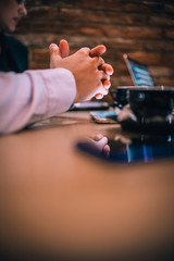 Closeup view on businessman's clasped hands on a cafe table