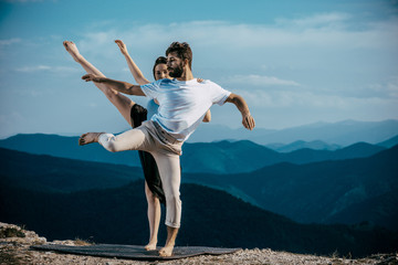 Modern style dancers posing on mountain against blue sky