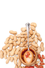 Creamy peanut butter in glass jar, peanut and spoon isolated on white background. A traditional product of American cuisine