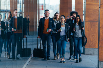 Group of colleagues on a business trip (euro trip) walking together at a modern  futuristic station