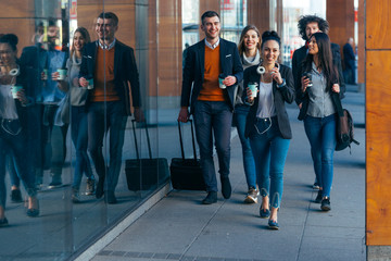 Group of colleagues on a business trip (euro trip) walking together at a modern  futuristic station