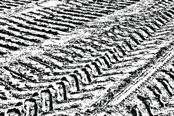 Grunge texture of vehicle tire tracks. Monochrome background of traces of truck on a dirt road. Overlay template. Vector illustration