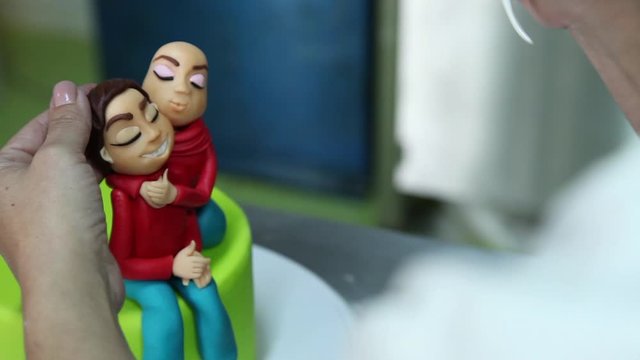 confectioner making figure from sugar paste fondant cake pastery