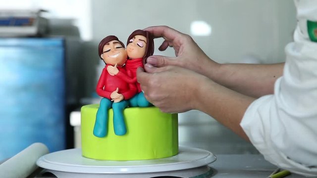 confectioner making figure from sugar paste fondant cake pastery