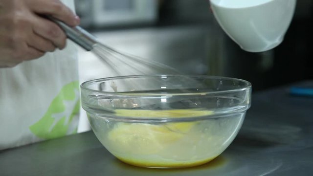Confectioner mixing eggs using fouet
