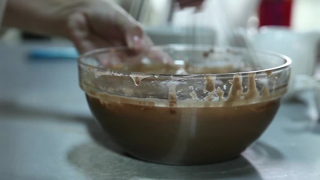 Confectioner mixing chocolate using fouet