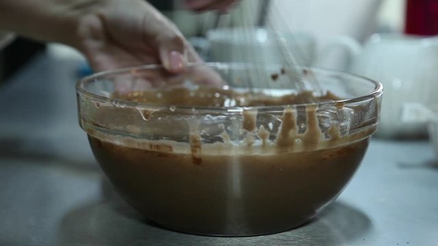 Confectioner mixing chocolate using fouet