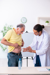 Fototapeta premium Doctor dietician giving advices to fat overweight patient