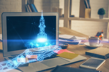Desktop computer background in office and start up theme hologram drawing. Double exposure. Startup concept.