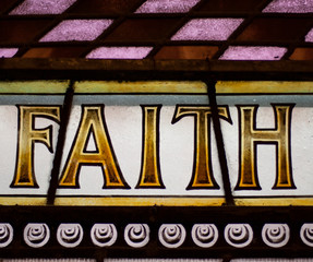 Vintage stained glass window with the message 'FAITH' in capital letters