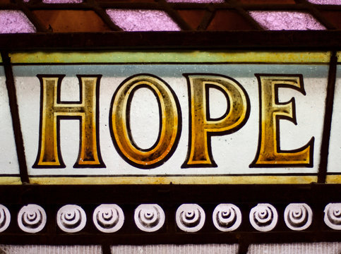 Vintage stained glass window with the message 'HOPE' in capital letters