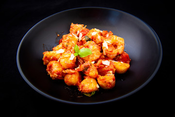 Gnocchi with tomato sauce and garnshied basil and cheese