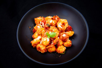 Gnocchi with tomato sauce and garnshied basil and cheese