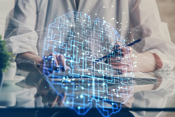 Multi exposure of writing hand on background with brain hologram. Concept of self learning.